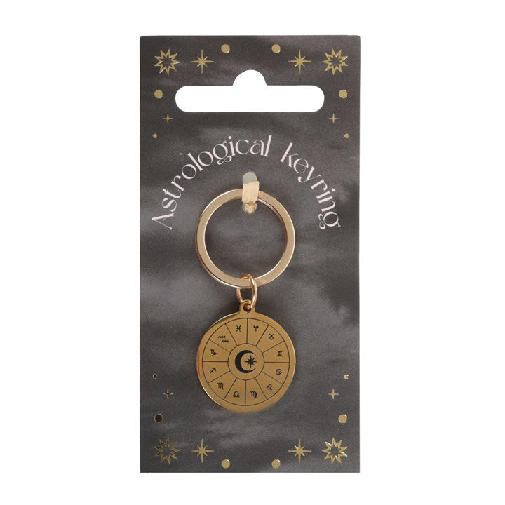 Gold astrological keyring on a black card with star designs