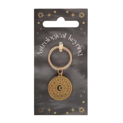 Gold astrological keyring on a black card with star designs