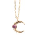 Gold necklace with a crescent moon pendant and pink gemstones on a plain background