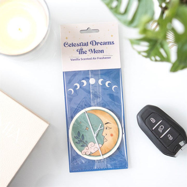 Celestial Dreams The Moon vanilla scented air freshener packaging on a white surface with a car key and plant in the background.