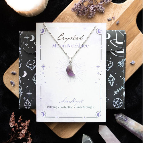 Crystal Moon Necklace on a branded card with decorative elements on a wooden board.