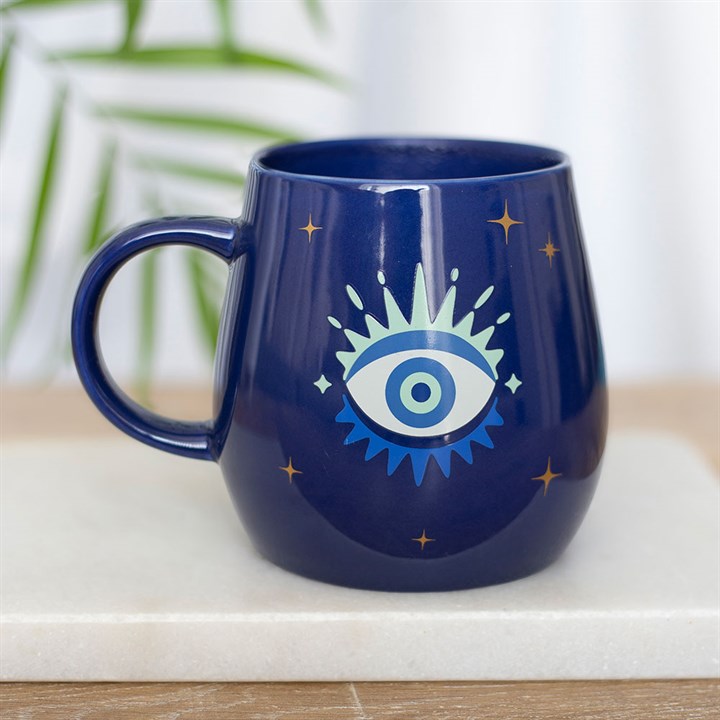 Navy blue mug with eye design on a light surface
