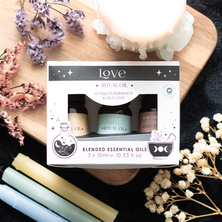 Box of blended essential oils with flowers and candles on a dark surface