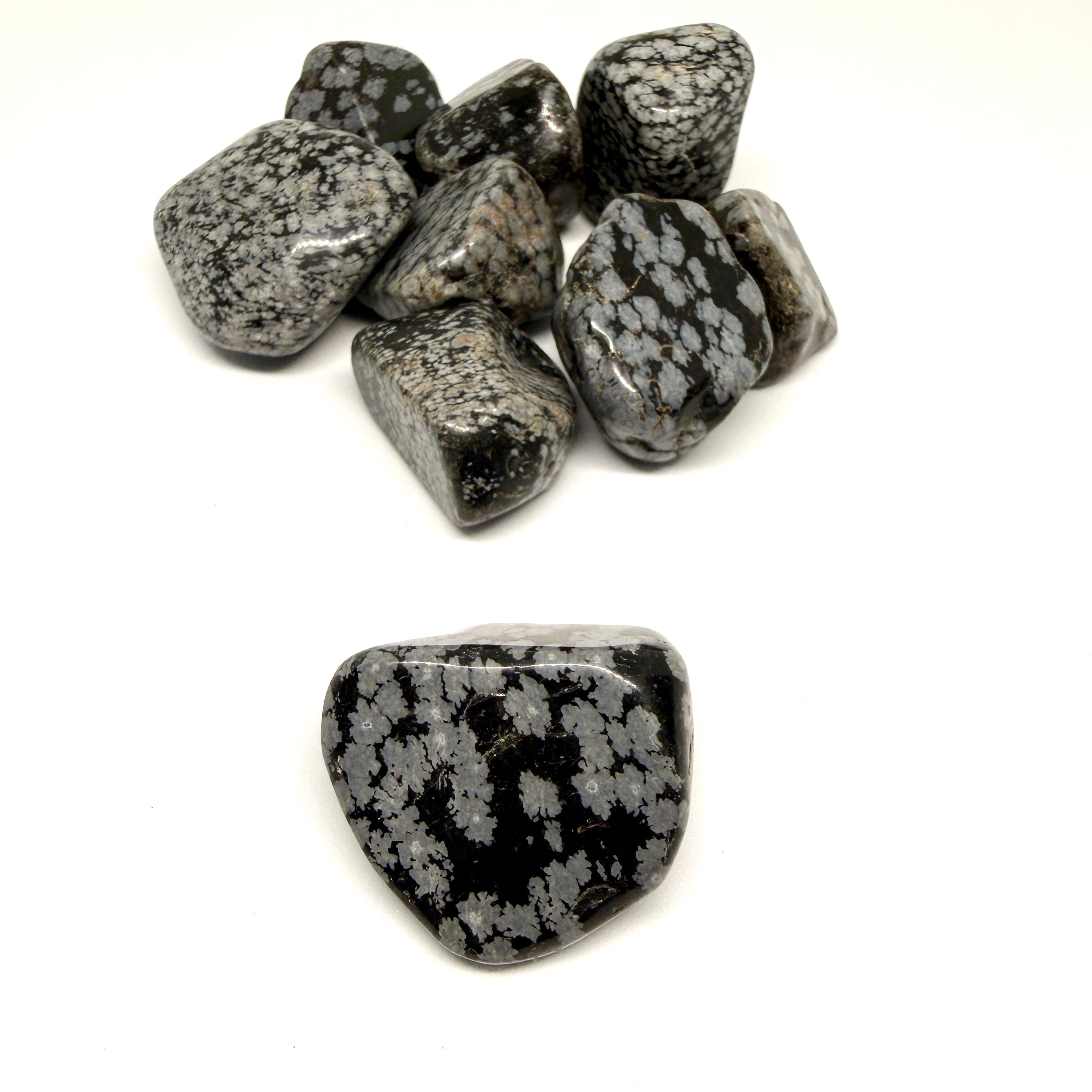 Tumbled snowflake obsidian stones on a white background