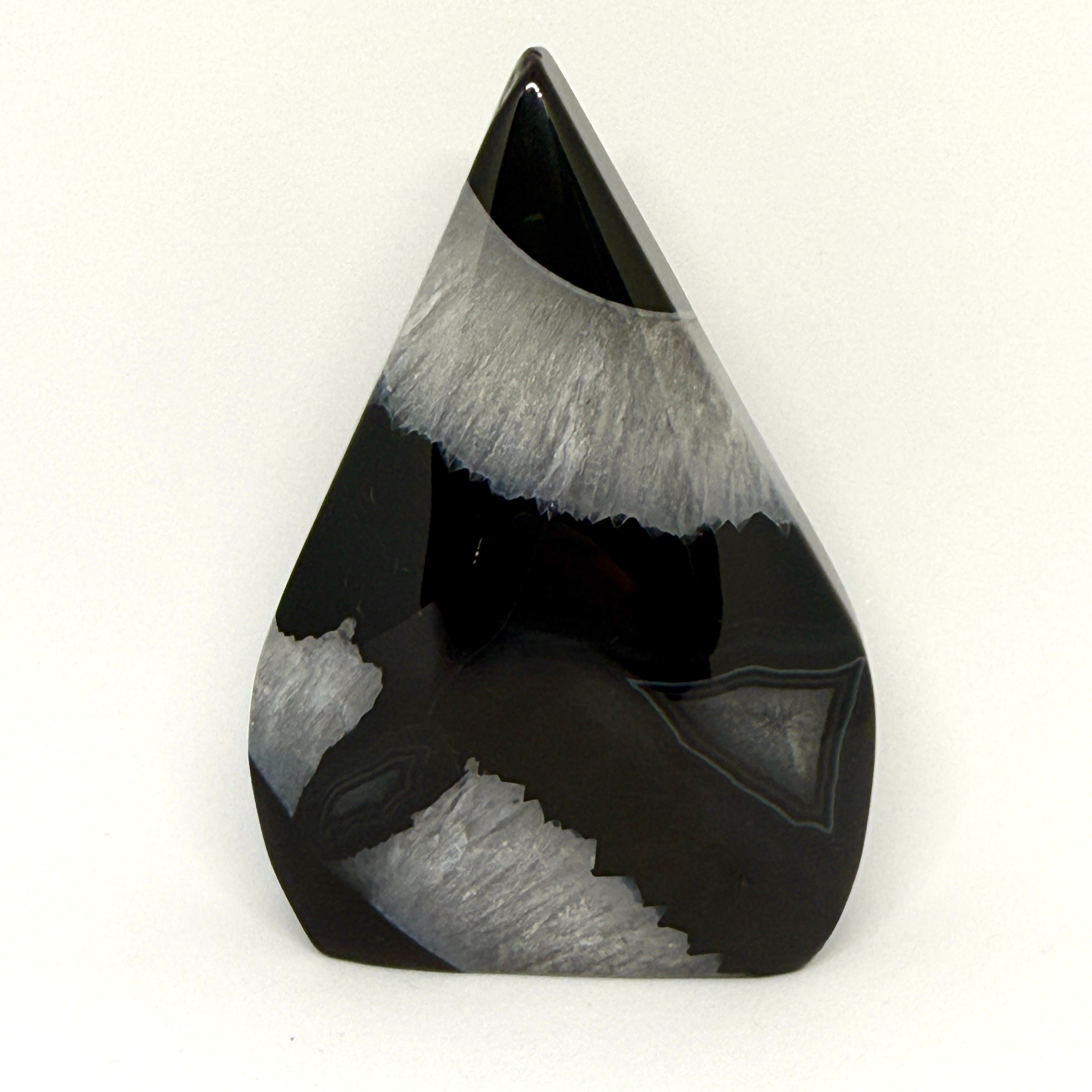 Teardrop-shaped black and gray stone on a white background