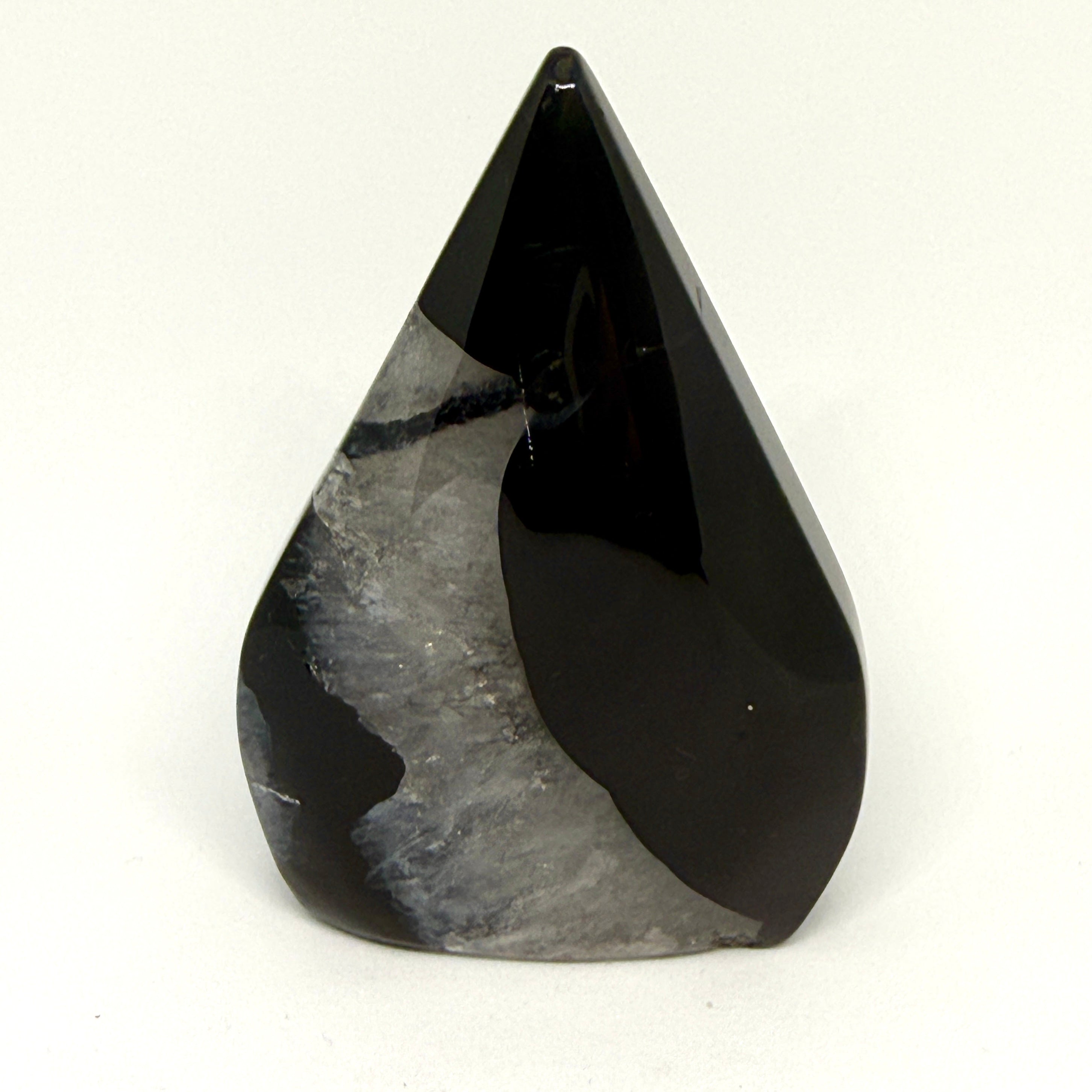 Teardrop-shaped black and gray stone on a white background