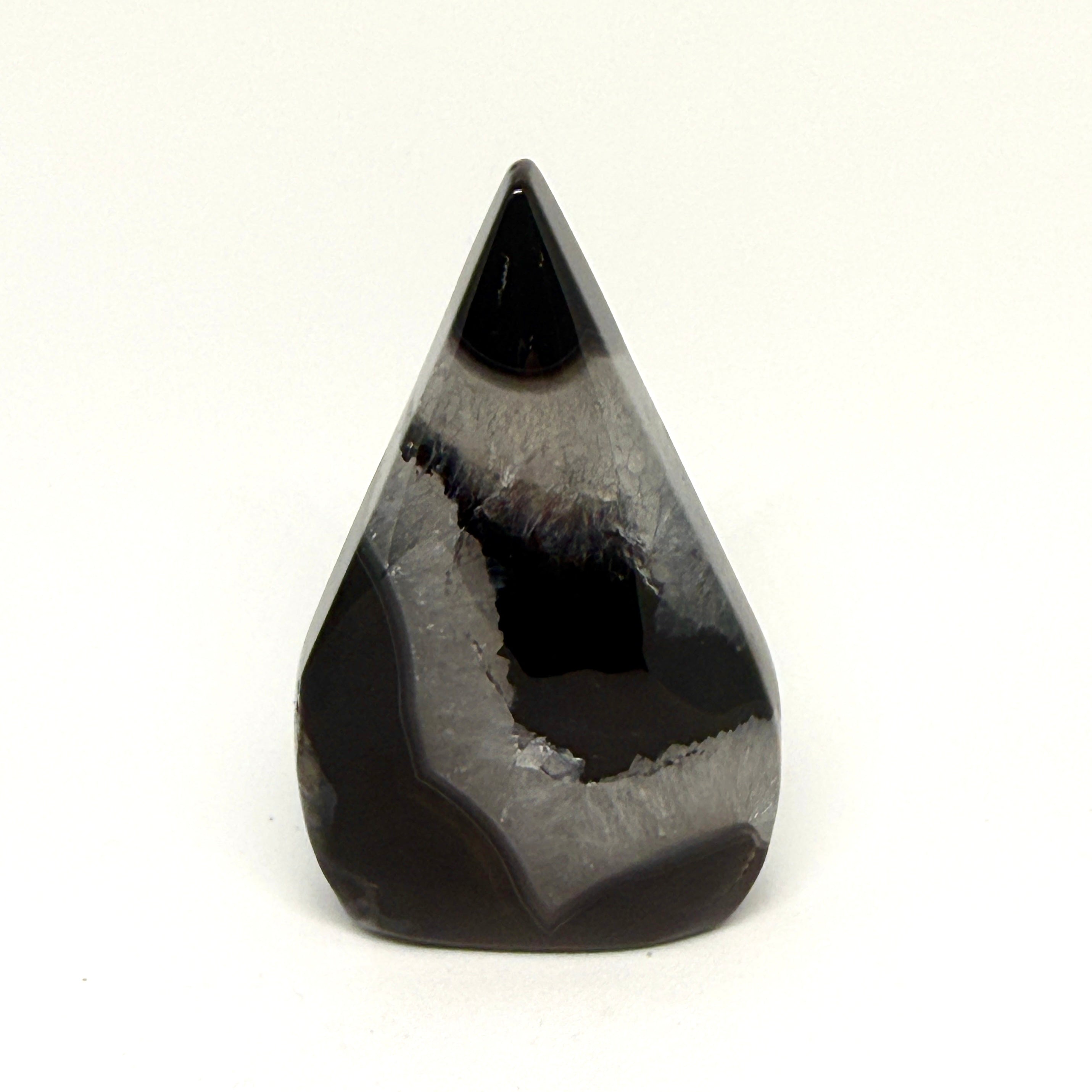 Teardrop-shaped black crystal on a white background