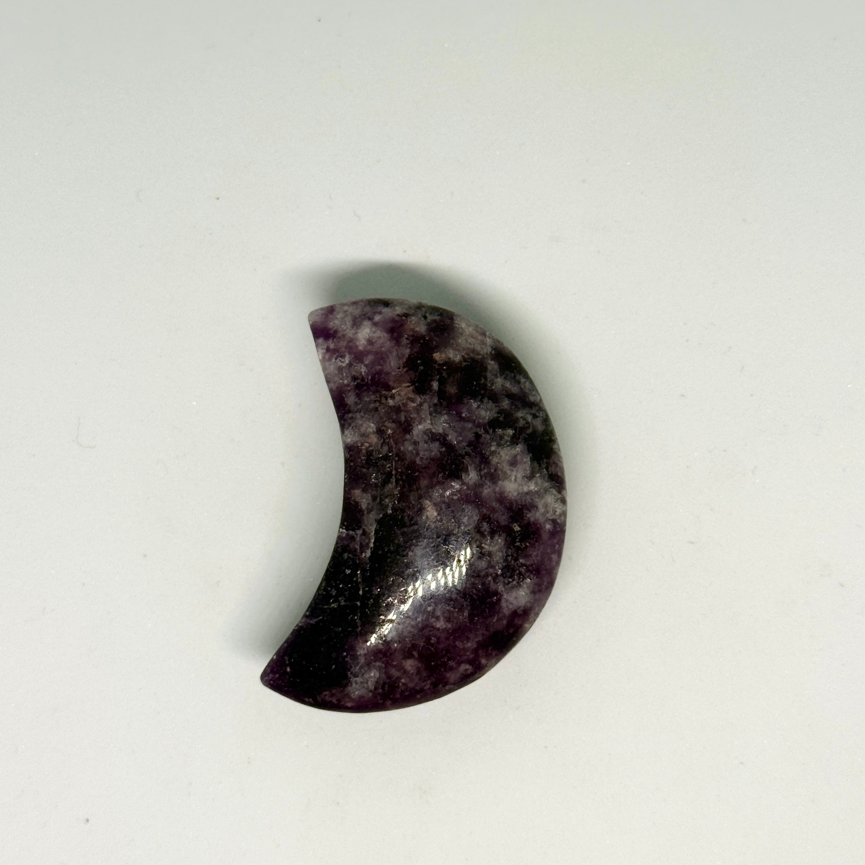 Crescent-shaped stone on a light gray background