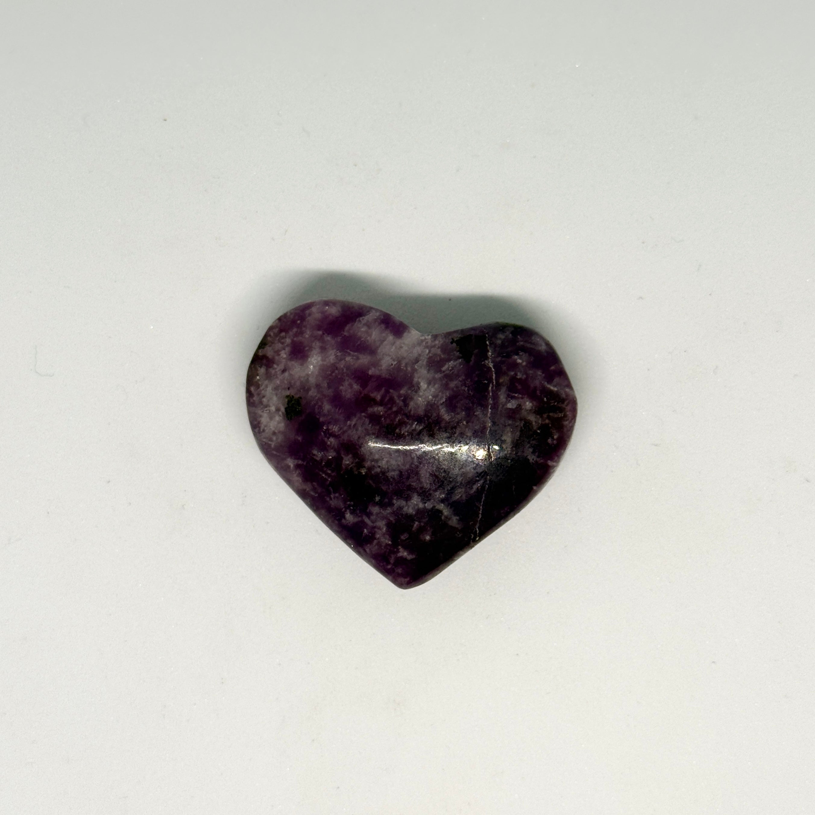 Heart-shaped purple stone on a white background