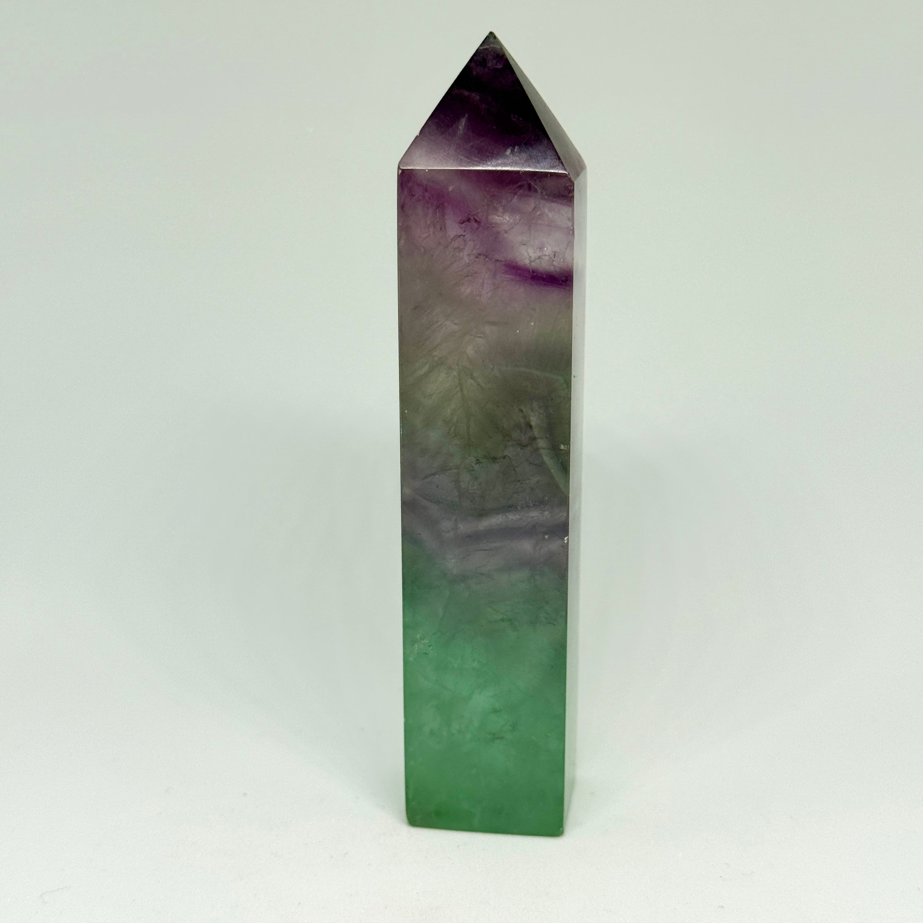 Tall, green and purple crystal tower on a white background