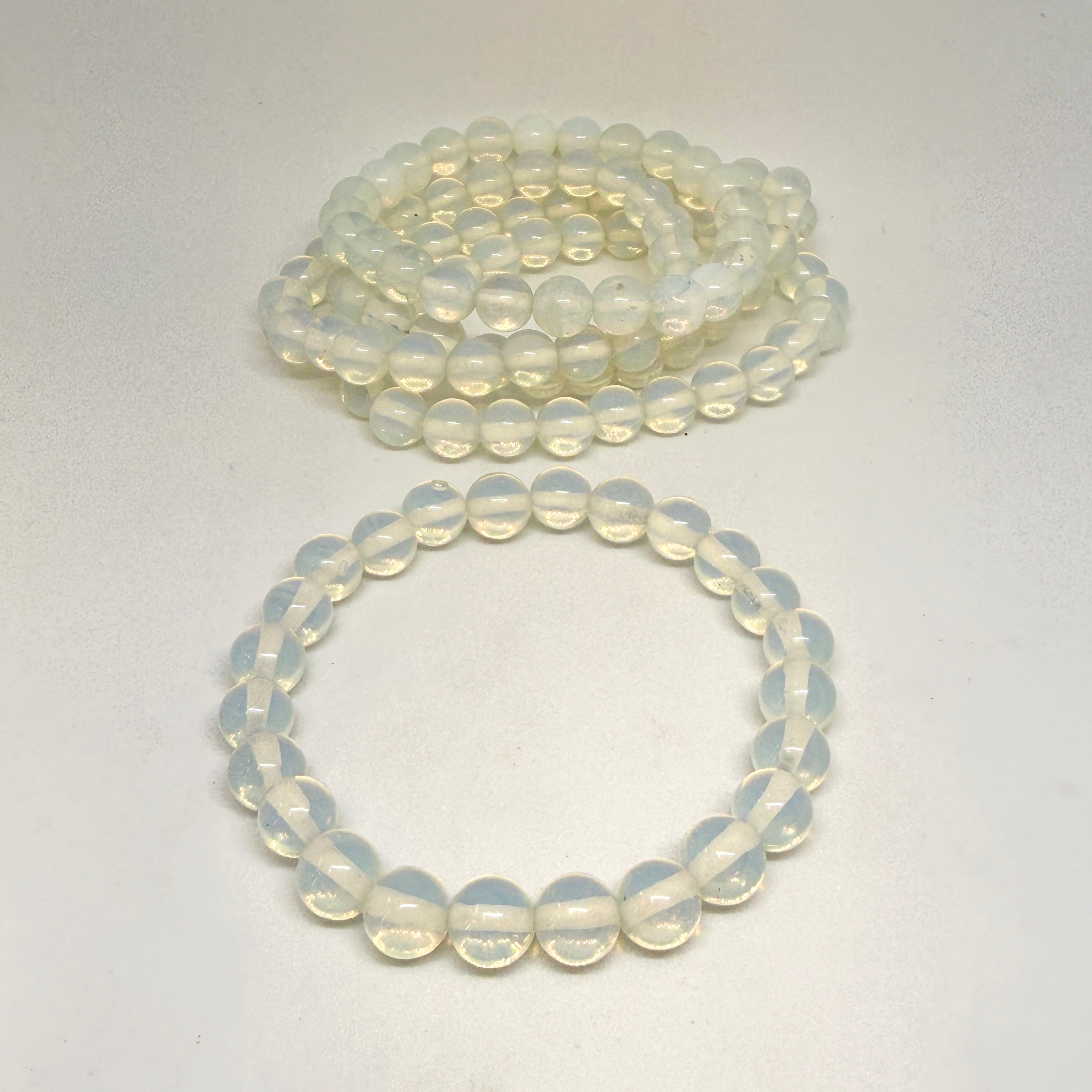 Two strands of light-colored beads on a white background