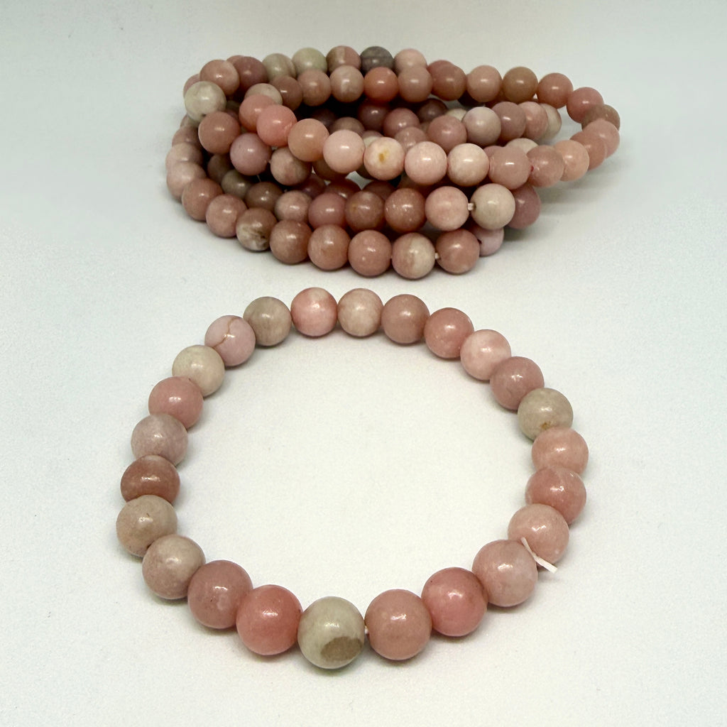 Two strands of pink and gray beads on a white background