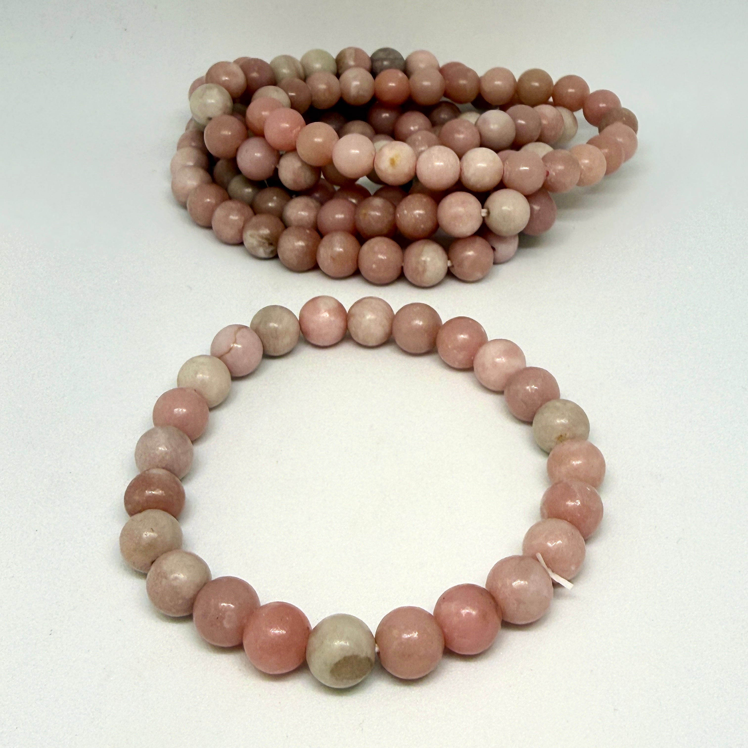 Two strands of pink and gray beads on a white background