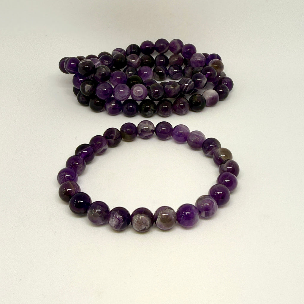 Two purple beaded bracelets on a white background