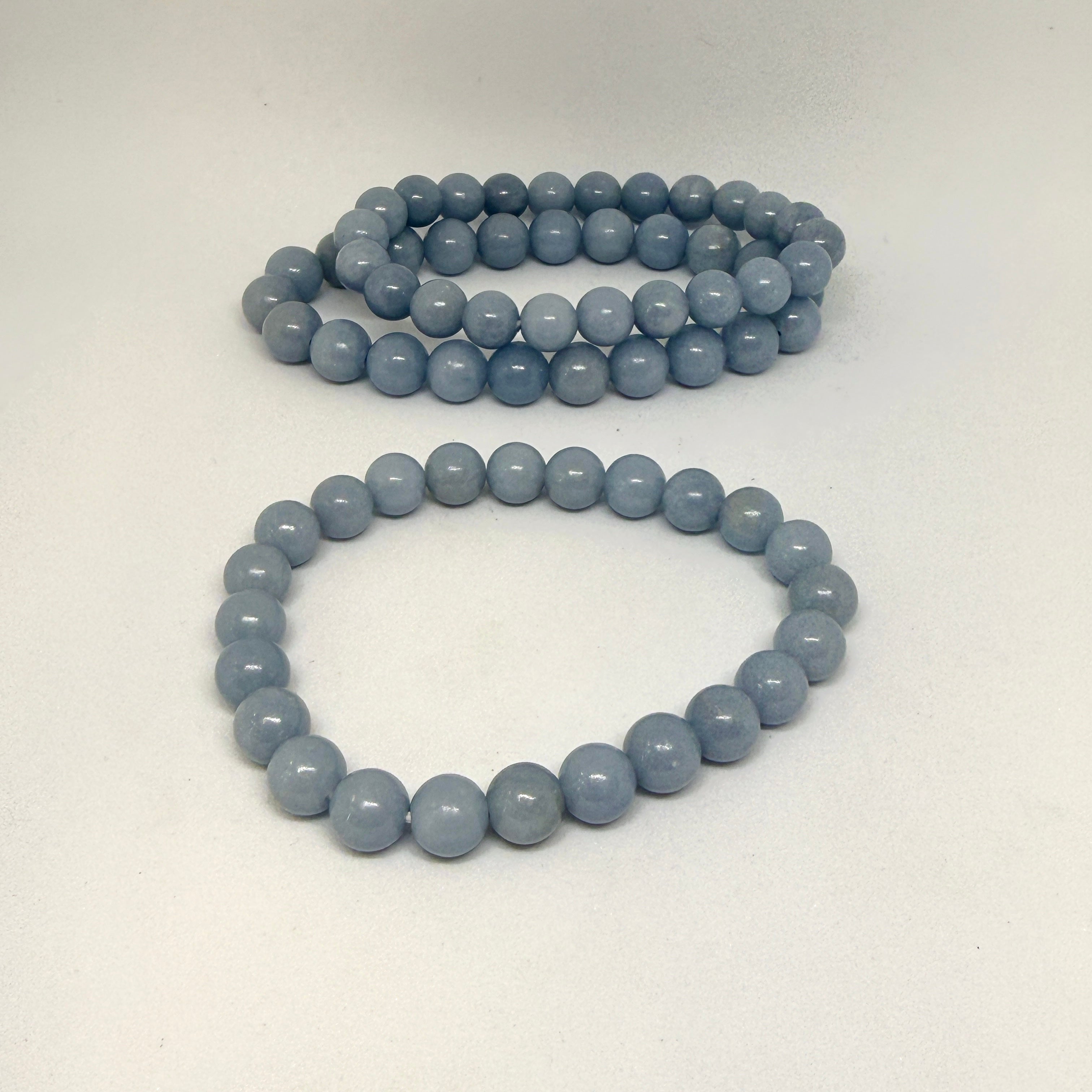 Two light blue beaded bracelets on a white background