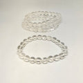 Two clear beaded bracelets on a light gray background