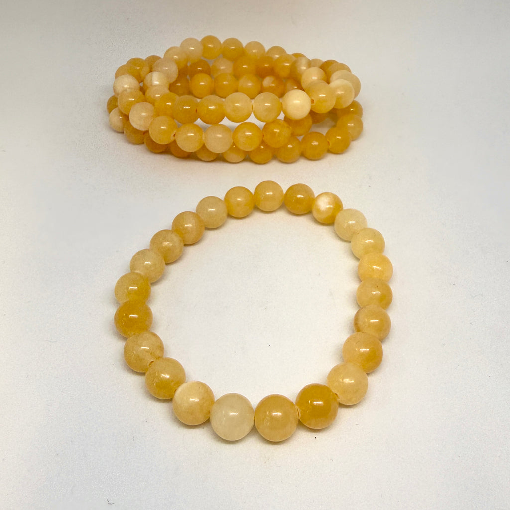 Two yellow beaded bracelets on a white background