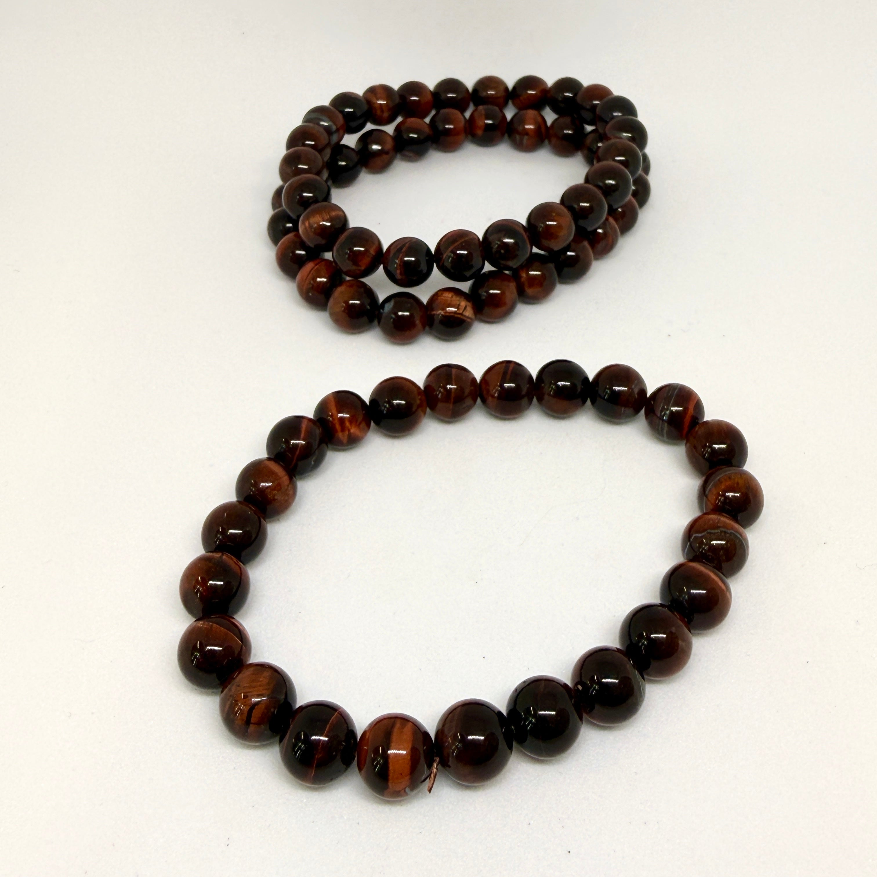 Two tiger eye beaded bracelets on a white background