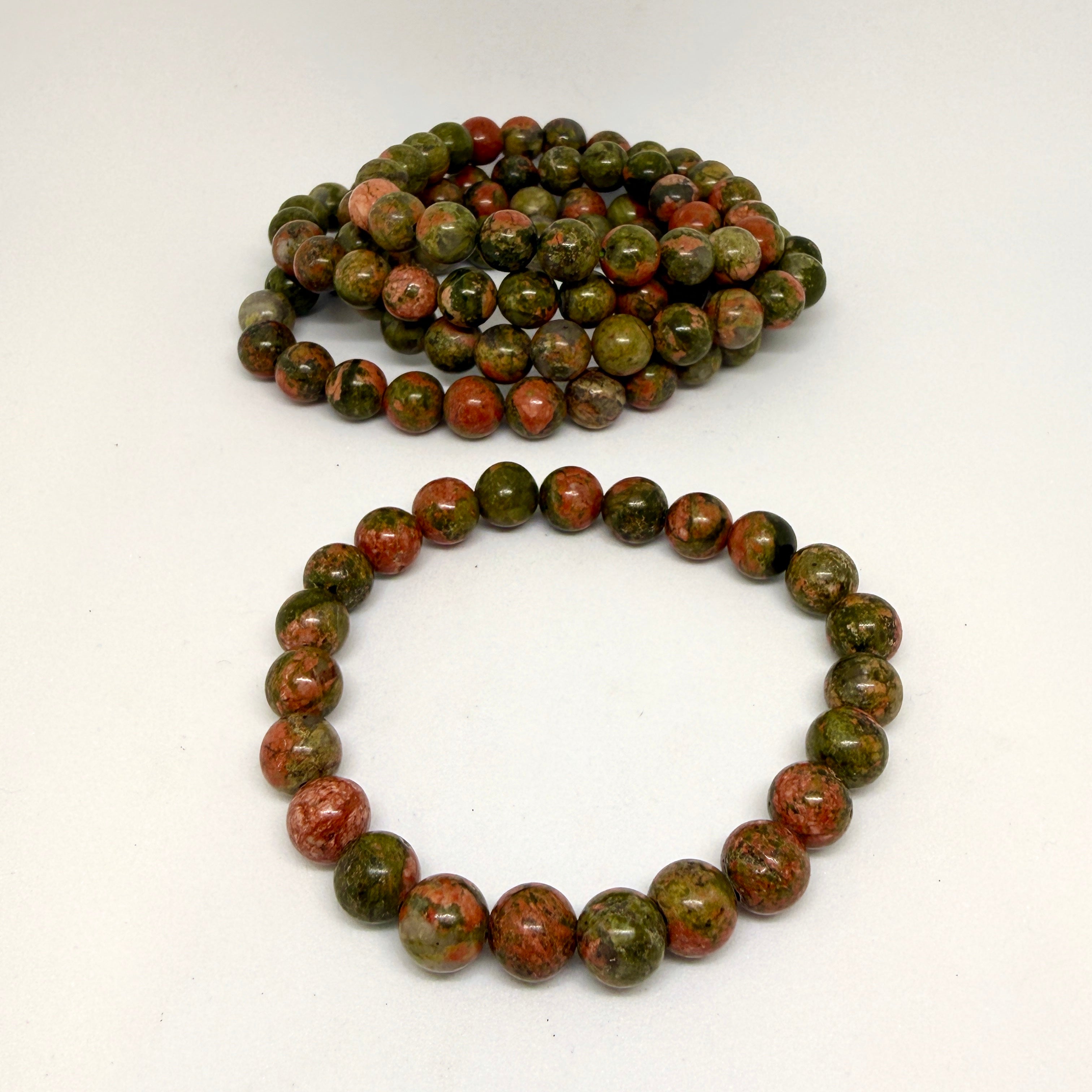 Two unakite beaded bracelets on a white background