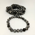 Two black and gray beaded bracelets on a white background