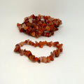 Two strands of orange and red beads on a white background