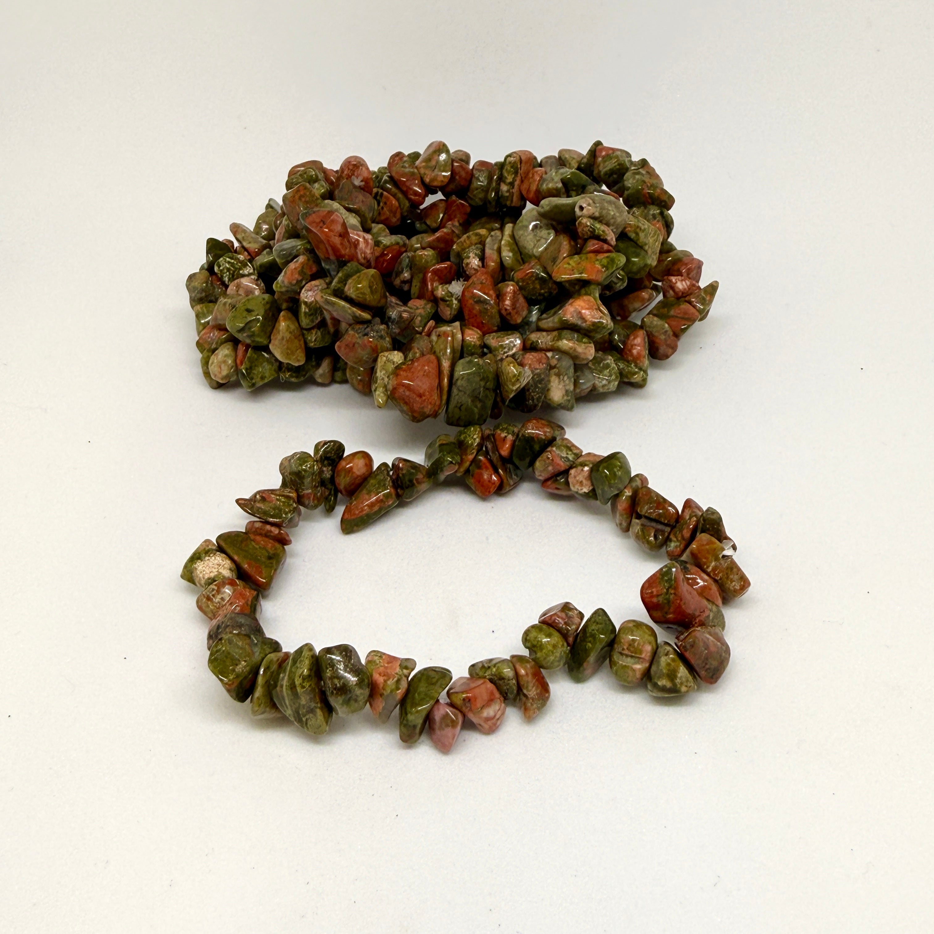 Bracelet made of green and brown stone beads on a white background
