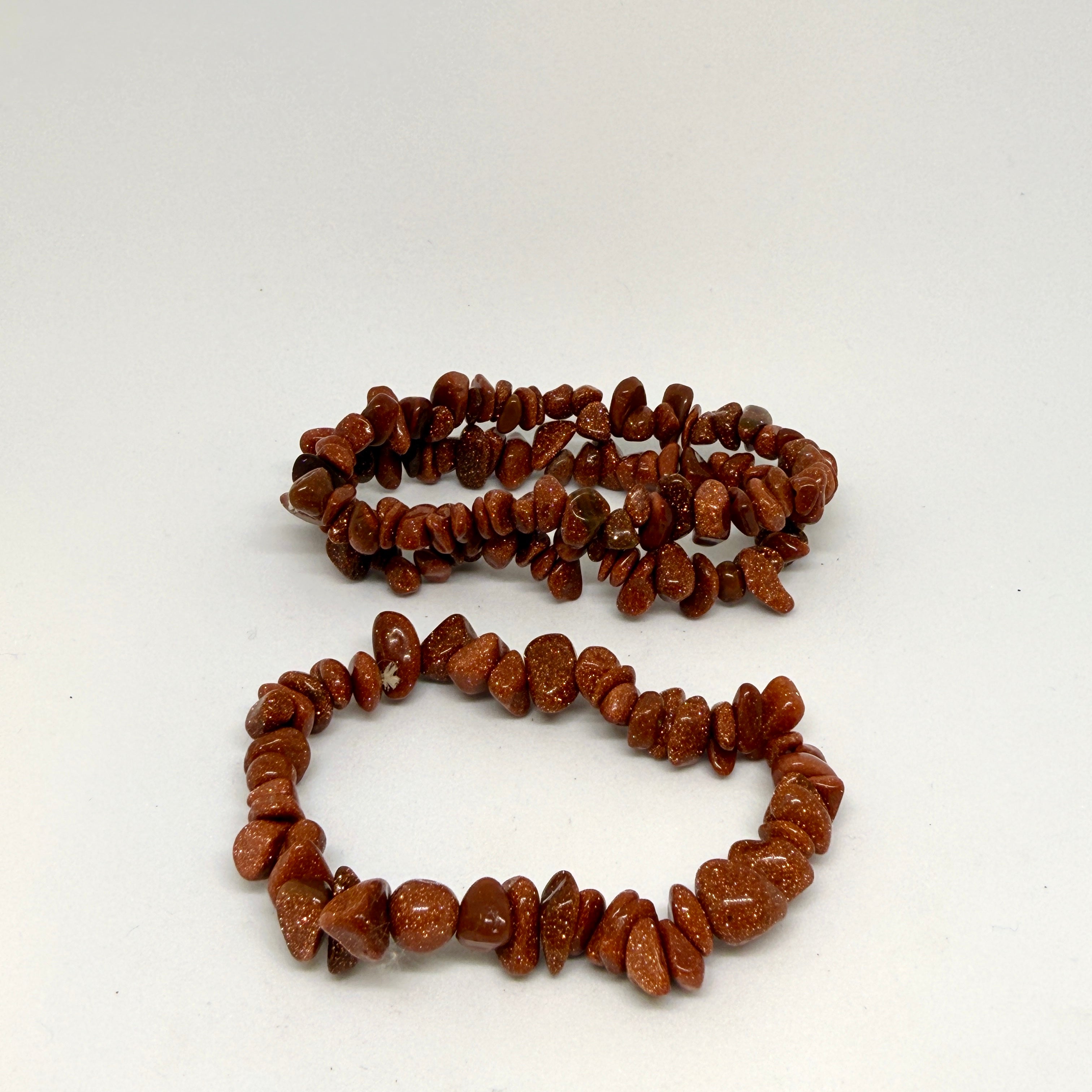Two brown stone beaded bracelets on a white background
