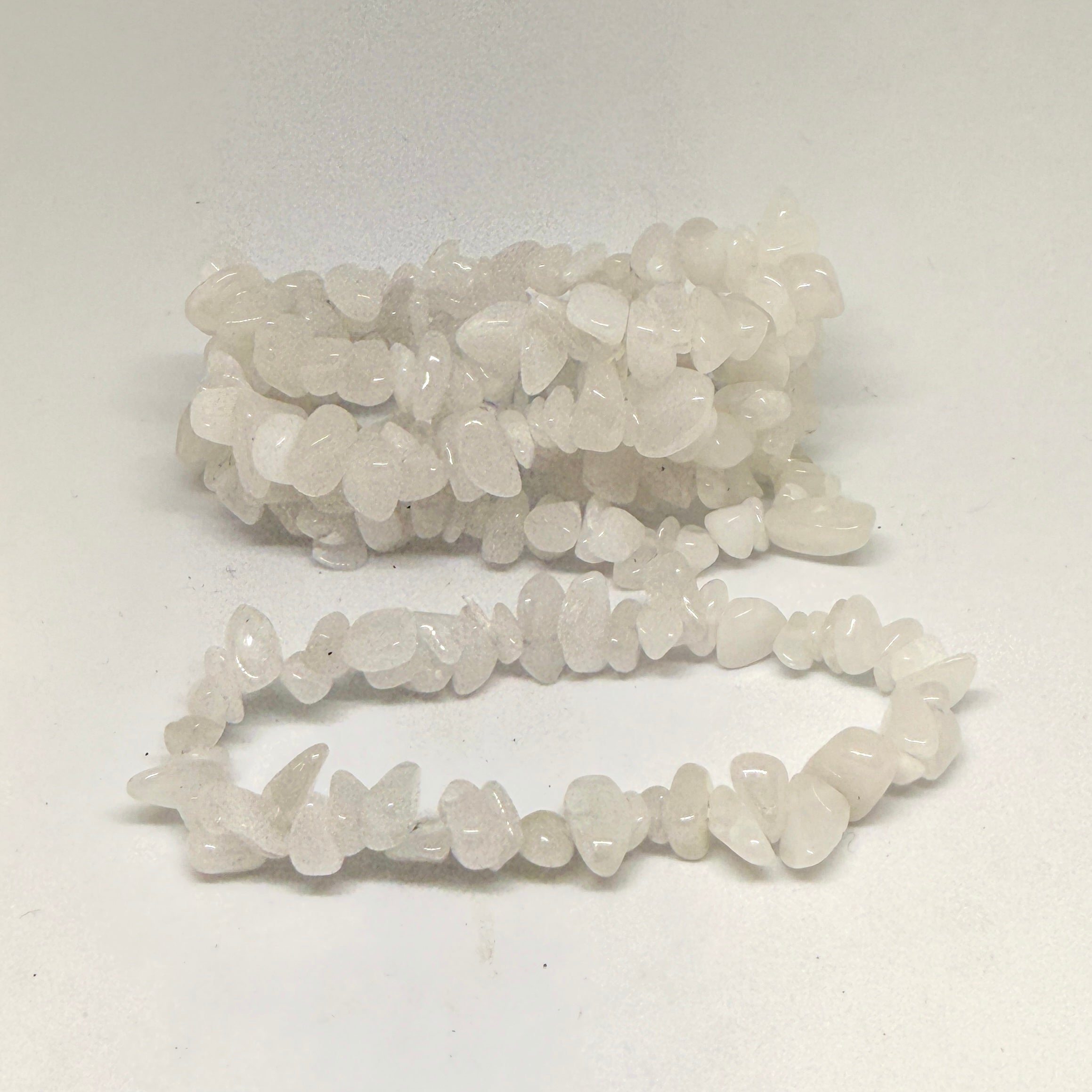 String of small white beads on a white background
