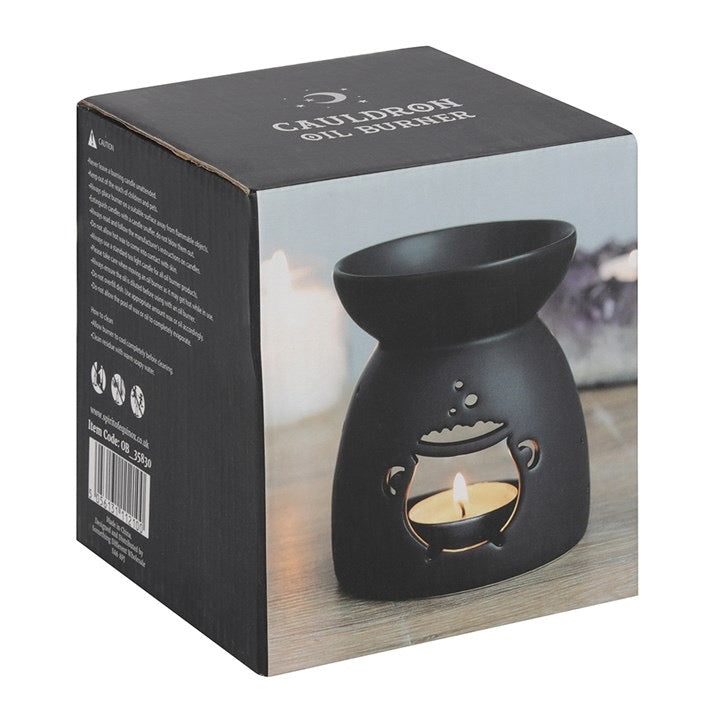 Black oil burner on a wooden surface with packaging displaying the brand name.