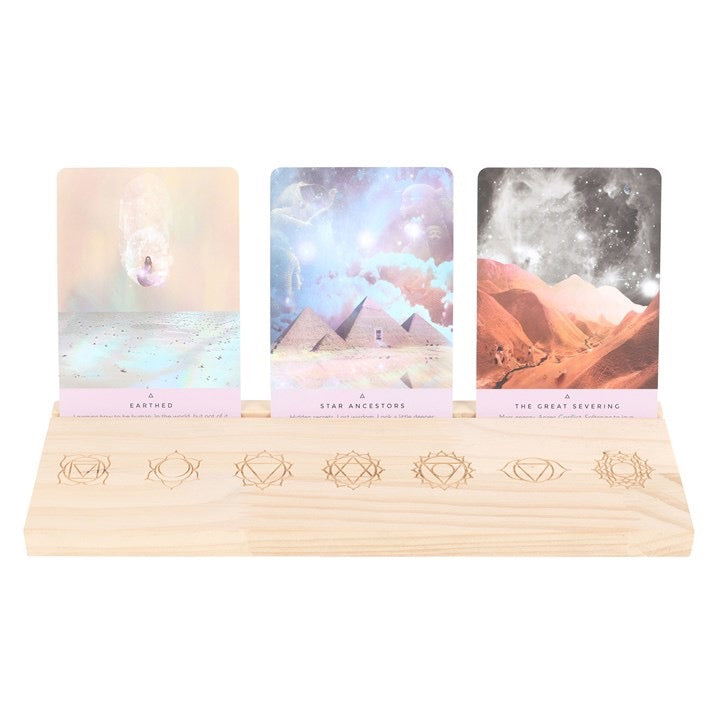 Three tarot cards on a wooden stand with mystical designs.