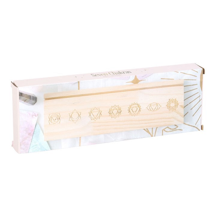 Wooden tool with symbols on a branded box against a white background