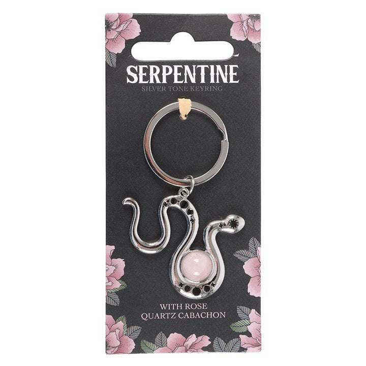 Serpentine silver tone keyring with rose quartz cabochon on a floral patterned card.