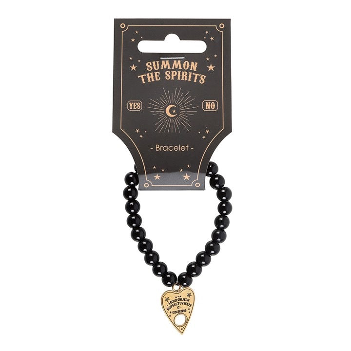 Black beaded bracelet with a gold heart-shaped charm on a 'Summon the Spirits' branded card.