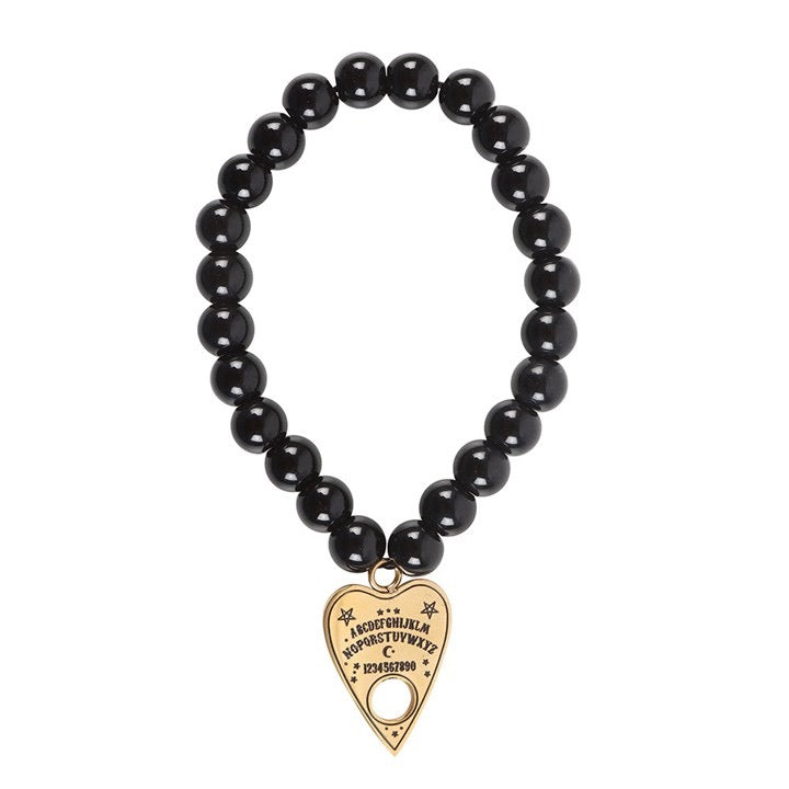Black beaded bracelet with a gold heart-shaped charm on a white background