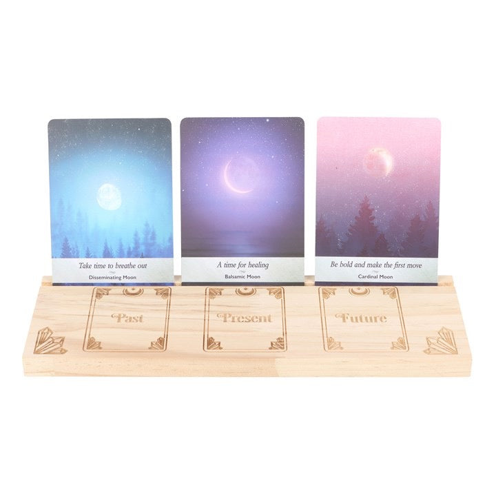 Three tarot cards on a wooden stand with engraved 'Past', 'Present', and 'Future' sections.