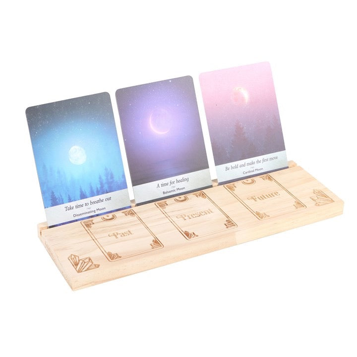 Three tarot cards on a wooden stand with gradient backgrounds