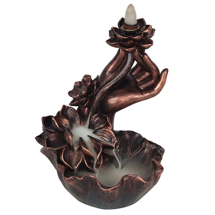 Decorative copper incense burner shaped like a hand holding flowers on a white background
