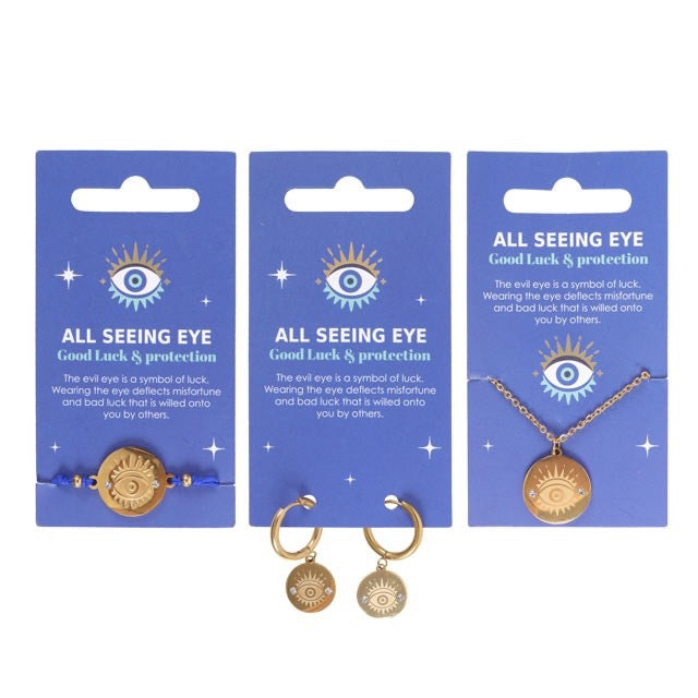 Three sets of 'All Seeing Eye' jewelry on blue cards with text.