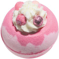Pink and white bath bomb with decorative elements on a white background