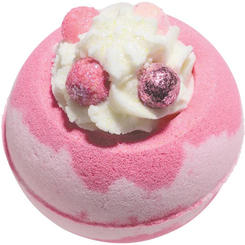 Pink and white bath bomb with decorative elements on a white background