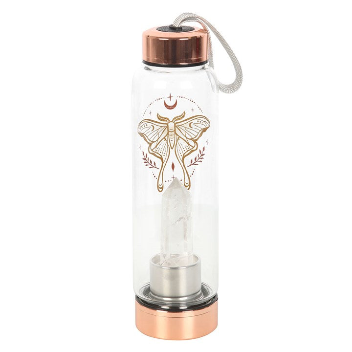Detail of clear quartz crystal point embedded in base of luna moth glass water bottle