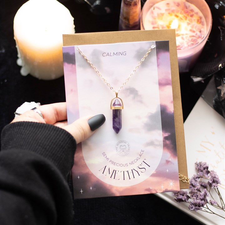 Amethyst necklace on a card with candles and flowers in the background