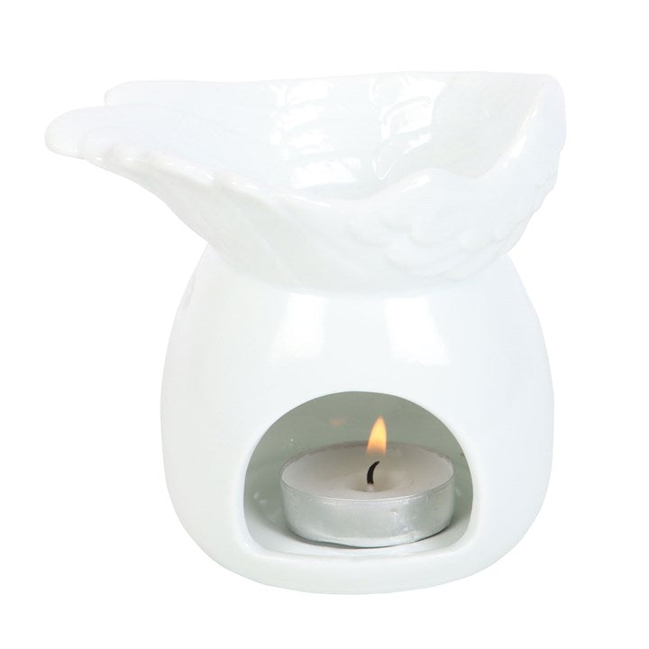White ceramic wax warmer with a lit tealight candle inside on a white background
