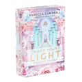 Box of 'Work Your Light' oracle cards by Rebecca Campbell with pastel designs and text.