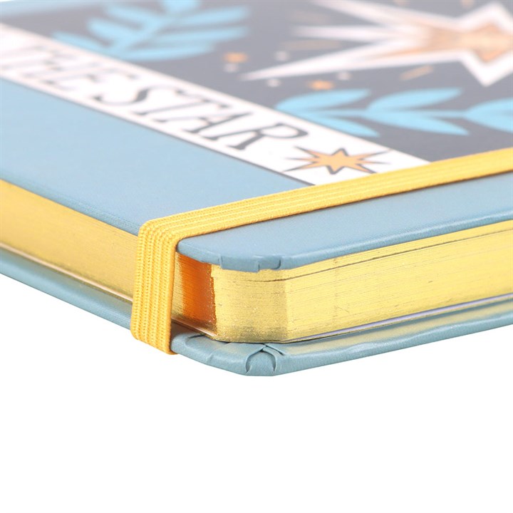 Close-up of a blue notebook with a gold elastic band on a white background