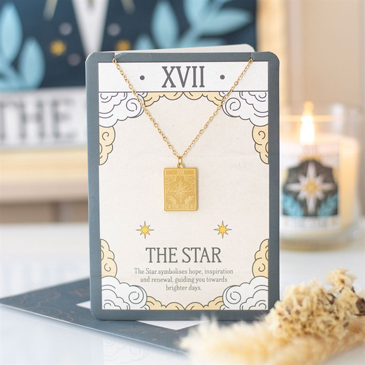 Gold necklace on a card with 'The Star' symbolism in a decorative setting
