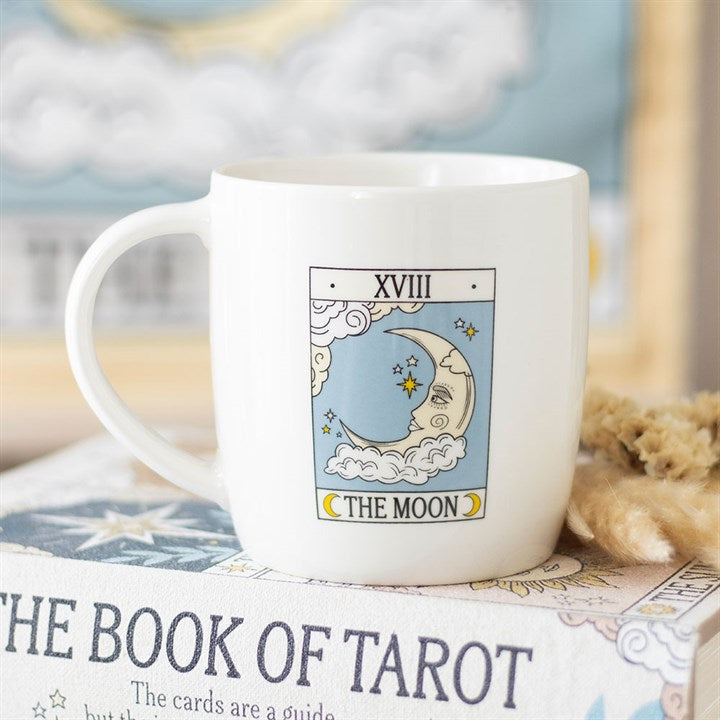 White mug with 'The Moon' tarot card design on a book titled 'The Book of Tarot'.
