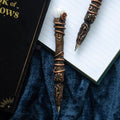 Decorative pen with intricate designs on a book and blue fabric background