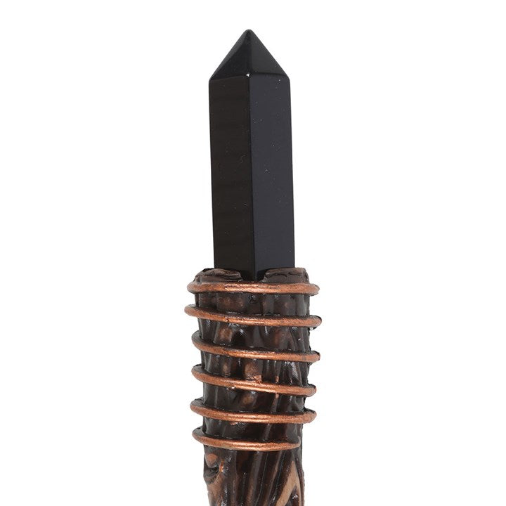 Black crystal point with bronze base on a white background