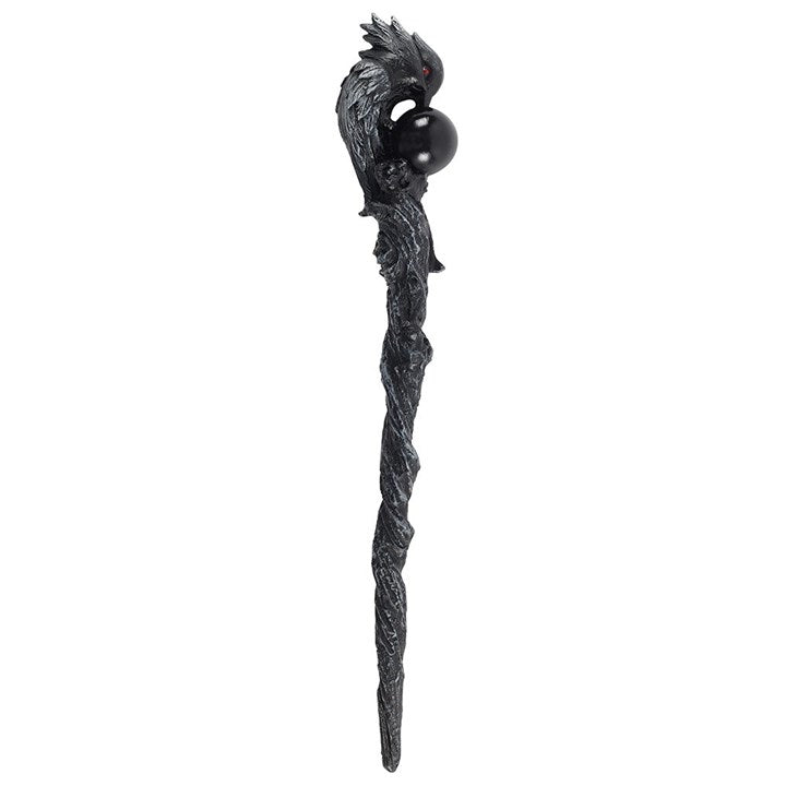 Decorative staff with dragon head and black sphere on a white background